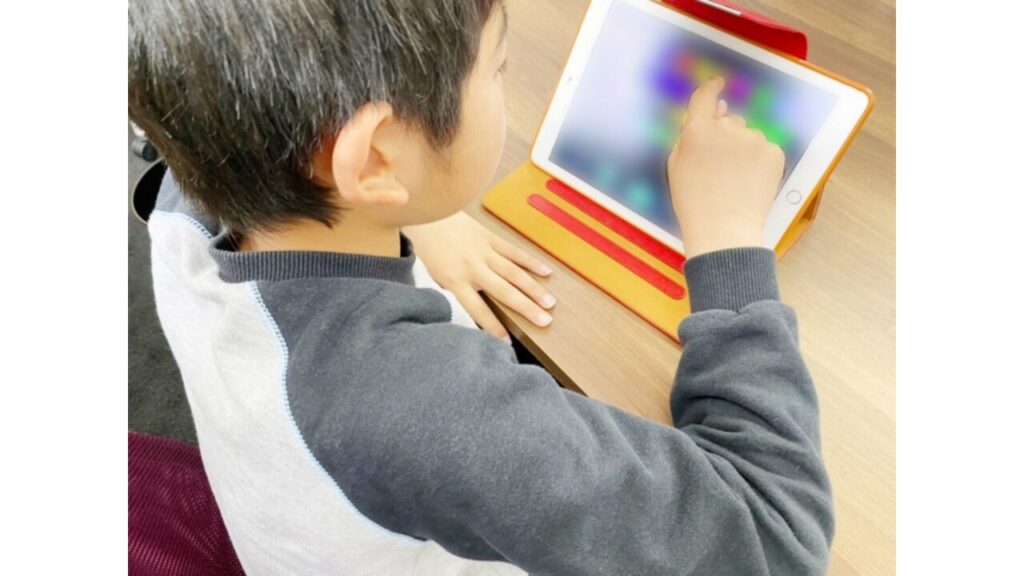 タブレットで英語学習をする子供